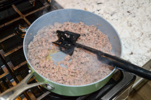 Cooked crumbled breakfast sausage in a skillet