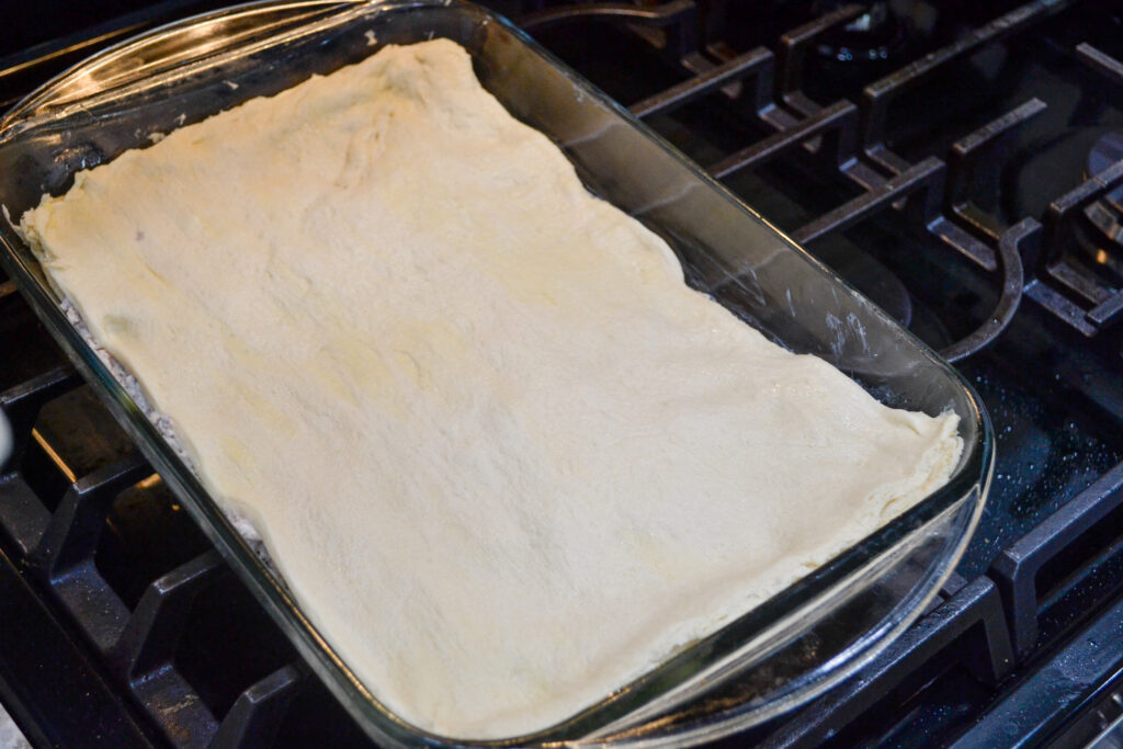 Second crescent dough sheet layered on top of the sausage filling