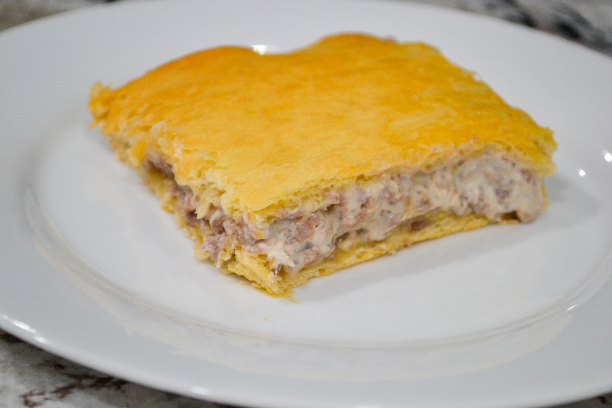 Close-up of sausage cream cheese crescent casserole with flaky golden crust