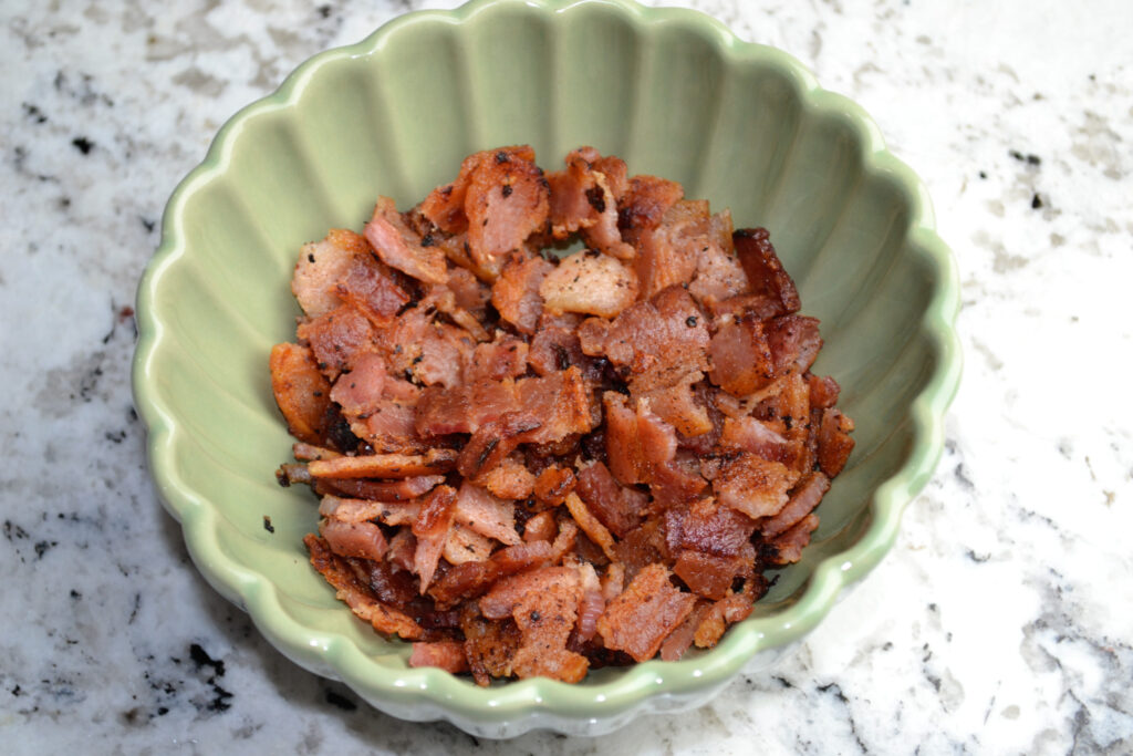 Crumbled crispy bacon in a green scalloped bowl