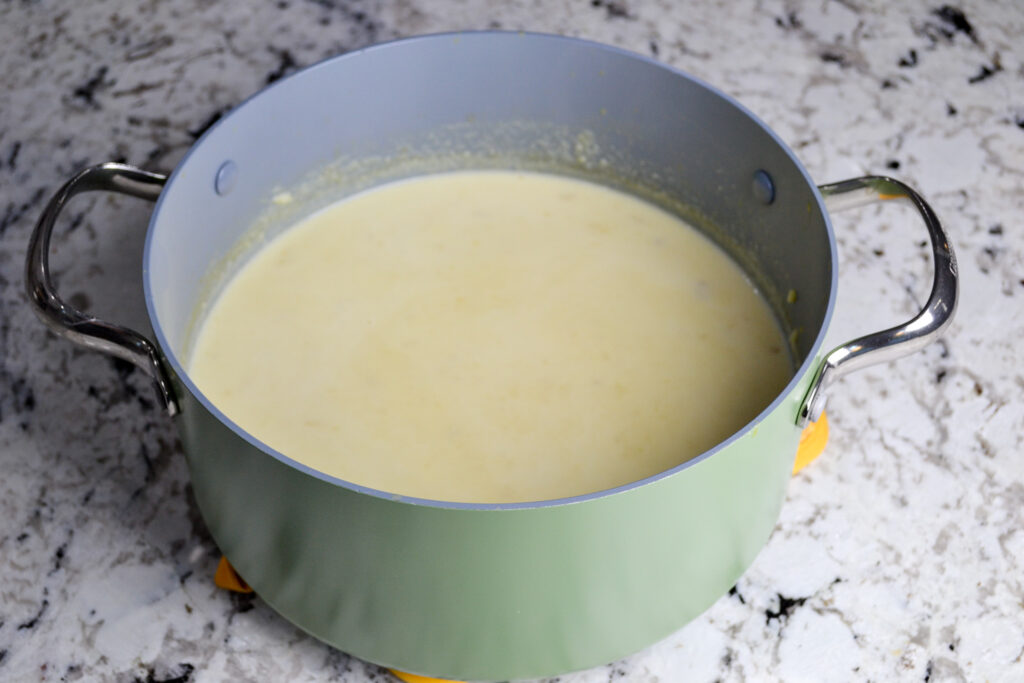 Creamy potato soup in a large pot after stirring in heavy cream