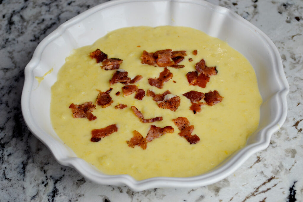 Bowl of creamy potato soup topped with crumbled bacon