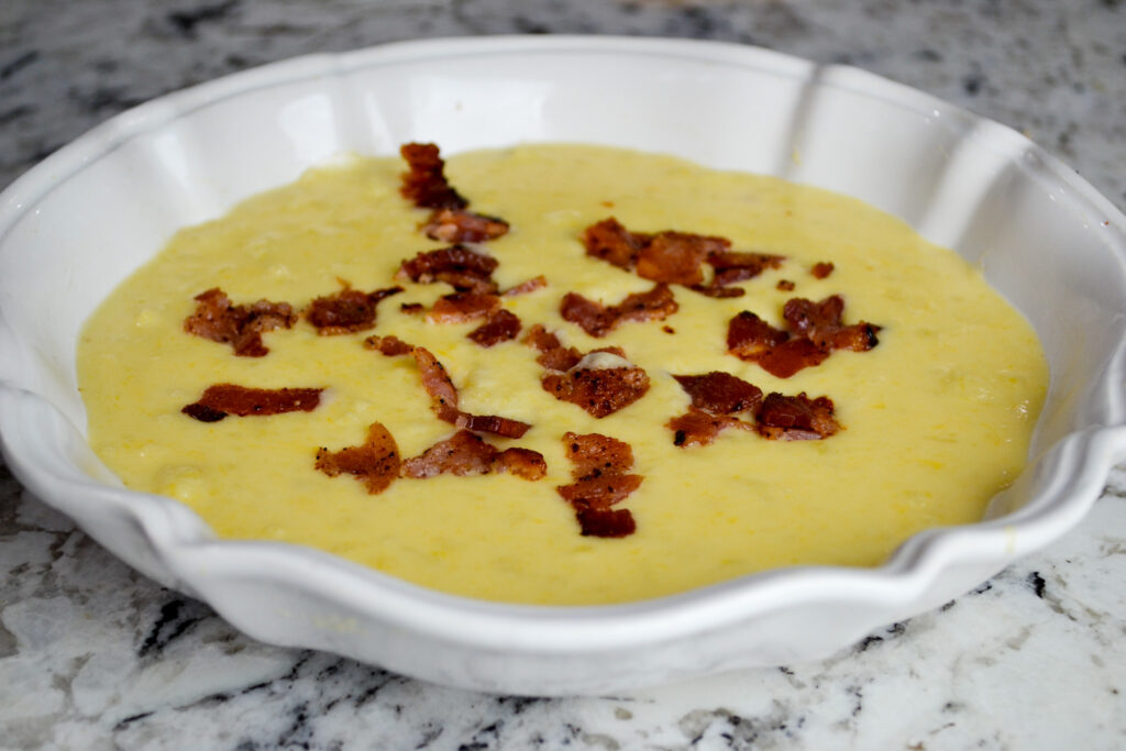 Creamy loaded potato soup with bacon in a white scalloped bowl
