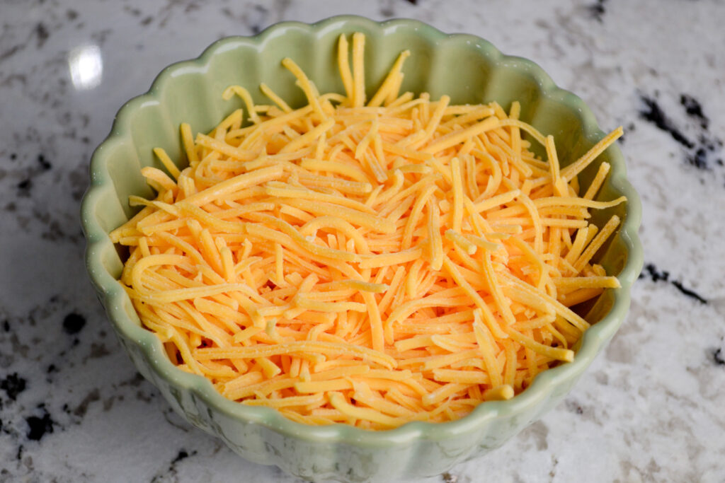 Bowl of freshly shredded cheddar cheese