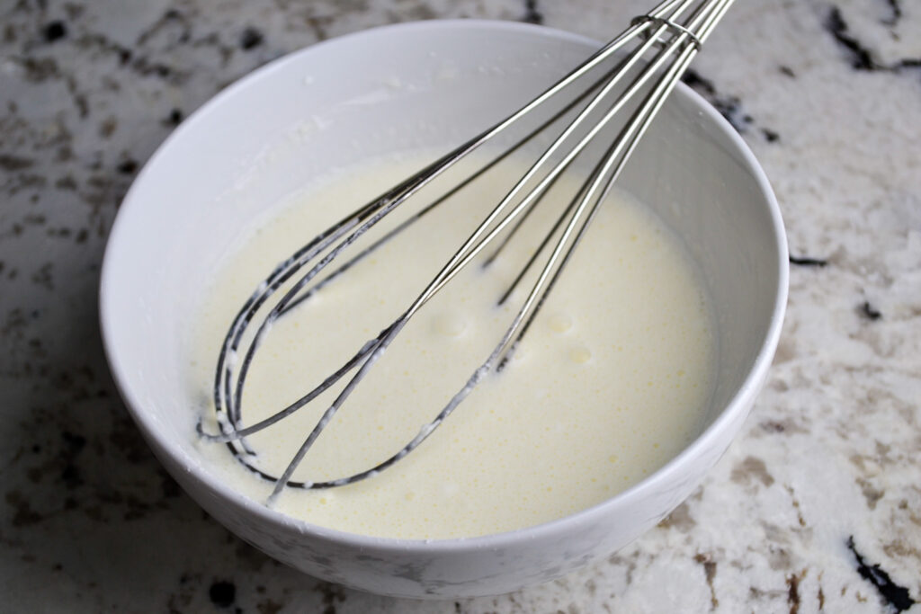 Cornstarch whisked into heavy cream in a white bowl