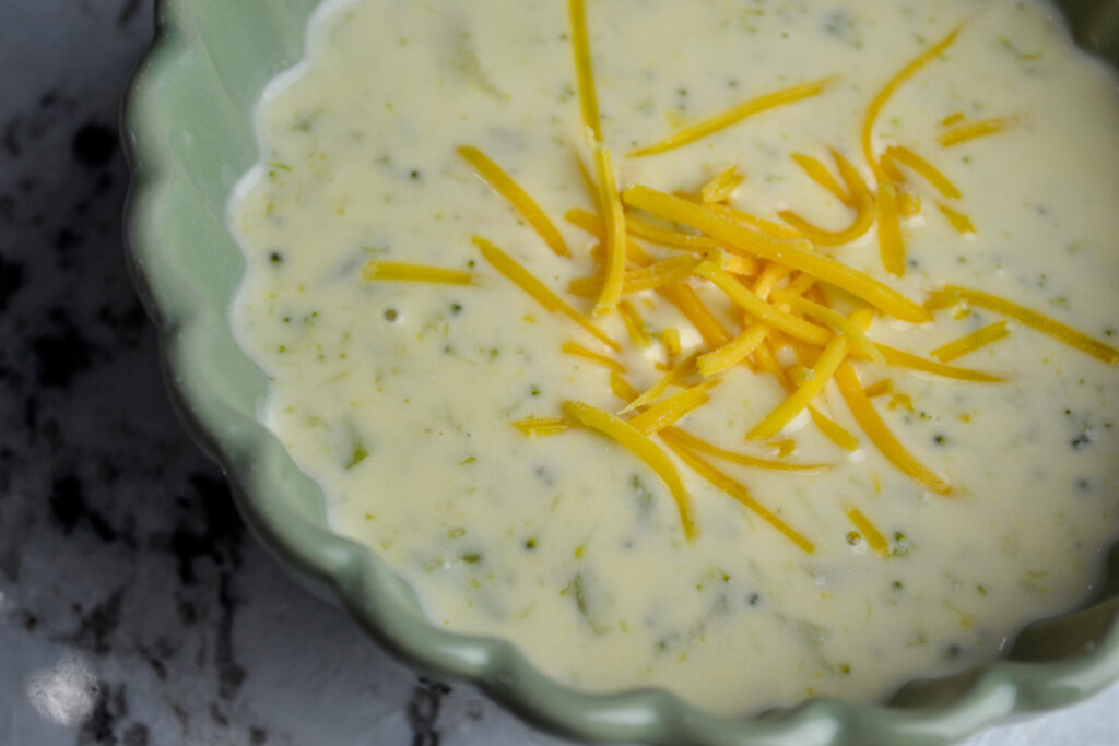 Creamy 5-ingredient broccoli cheddar soup with shredded cheddar on top