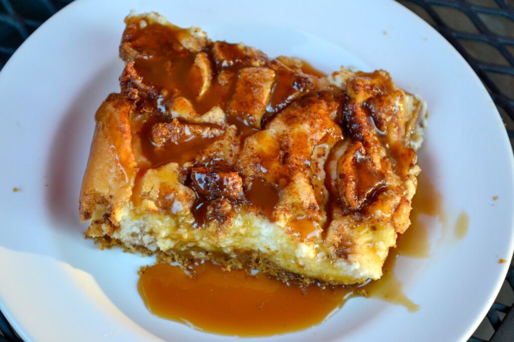 Overhead view of a caramel apple cheesecake bar drizzled with caramel sauce