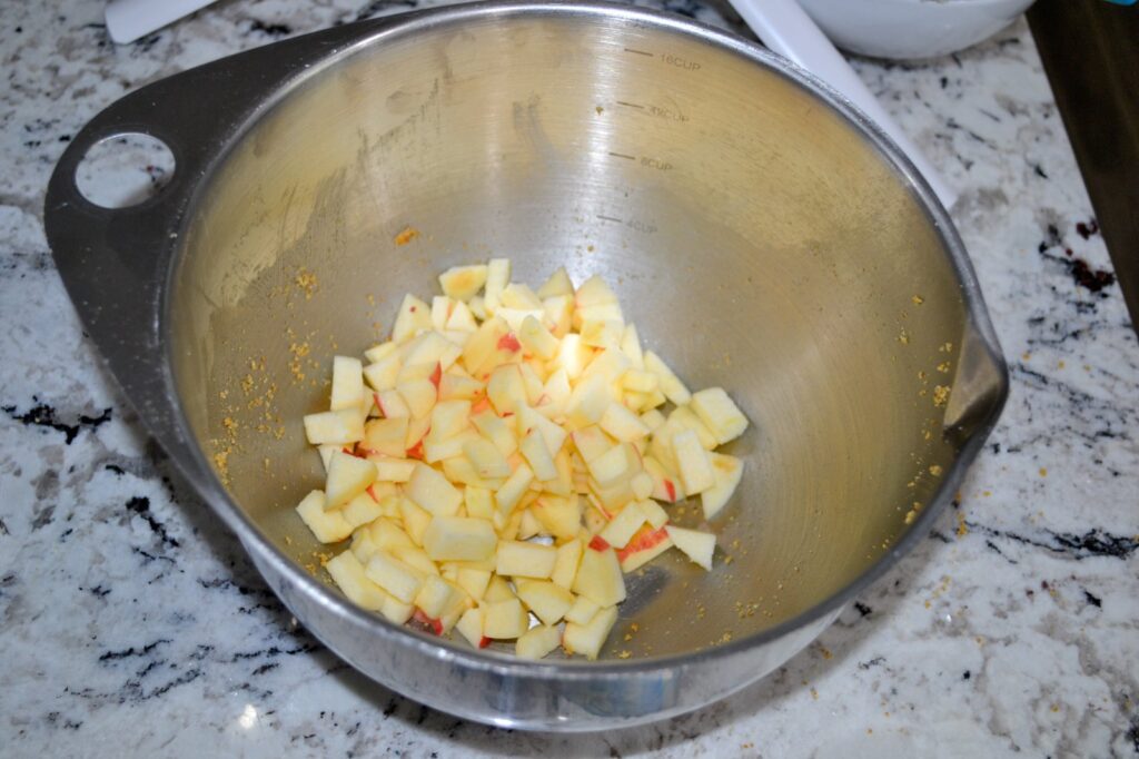 Peeled and diced apples in a stainless steel mixing bowl